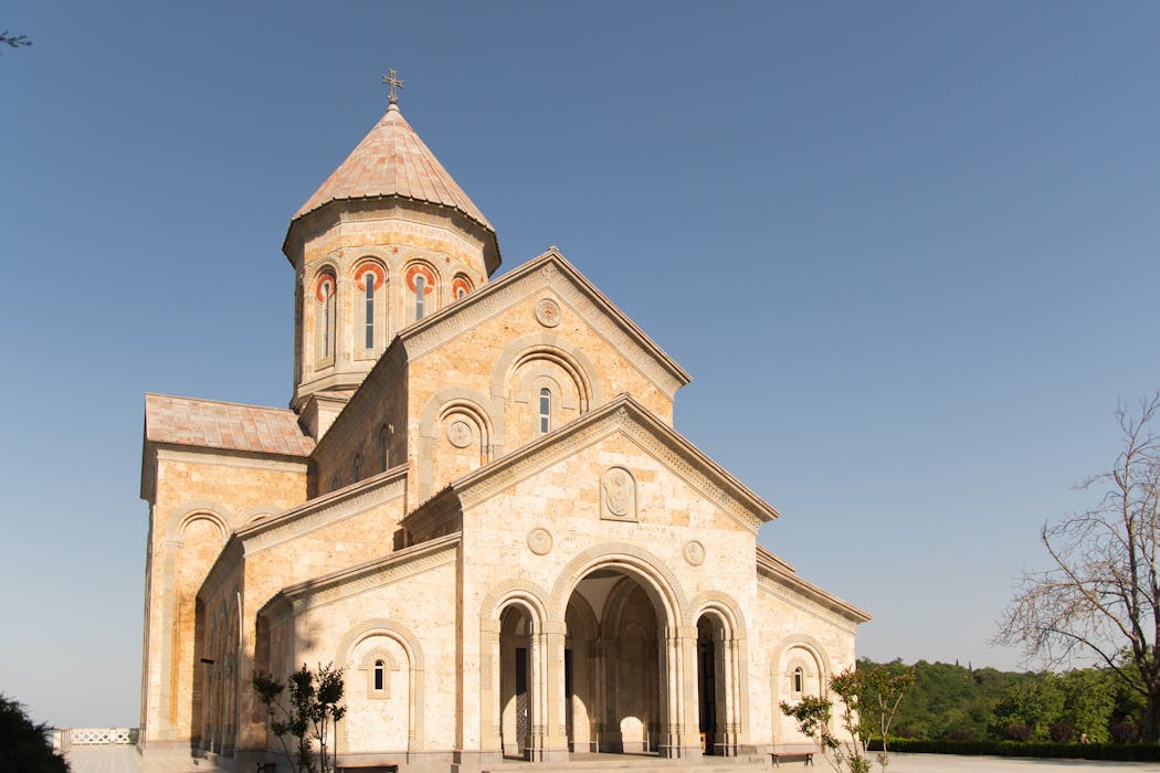 A beautiful historic stone church stands under a clear blue sky, representing architectural elegance.