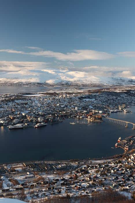 A captivating aerial view of Tromsø, Norway, showcasing its stunning snowy cityscape and surrounding landscapes.