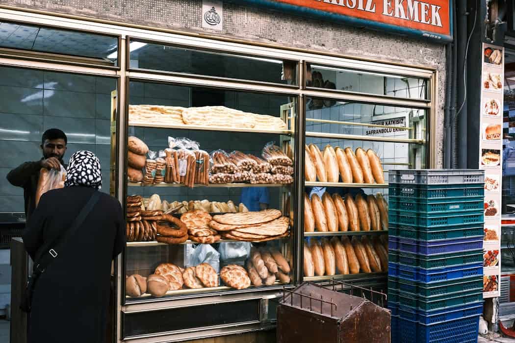 Outdoor bakery showcasing a variety of traditional breads and pastry offerings through a window display.